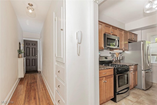 2725 Hampshire Rd Unit 2, Cleveland Heights, OH 44106 - kitchen featuring stainless steel appliances, dark stone countertops, brown cabinets, and light wood-style floors