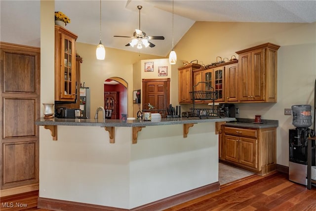 471 Buck Run, Pennsboro, WV 26415 - kitchen featuring a kitchen breakfast bar, brown cabinets, a ceiling fan, vaulted ceiling, and wood finished floors