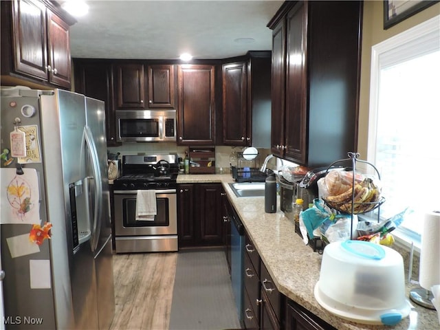 14610 Onaway Rd, Shaker Heights, OH 44120 - kitchen with stainless steel appliances, dark brown cabinetry, light stone countertops, and light wood finished floors