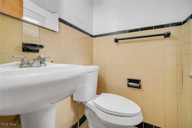 1540 S Belvoir Blvd, South Euclid, OH 44121 - bathroom featuring tile walls, toilet, and a sink