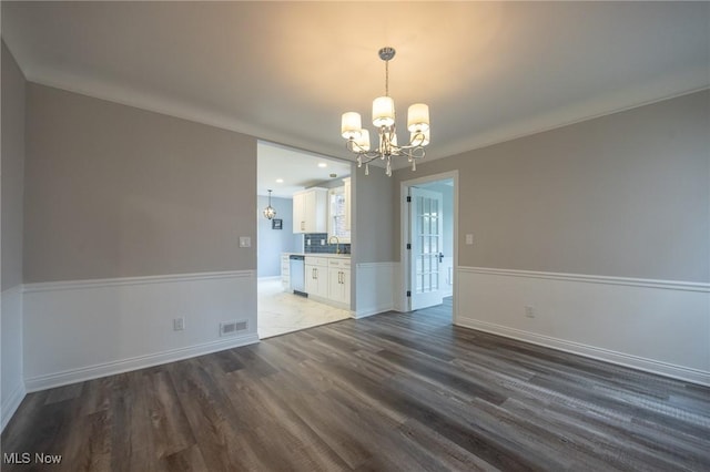 17607 Scottsdale Blvd, Shaker Heights, OH 44120 - unfurnished dining area featuring a chandelier, wood finished floors, baseboards, and a sink