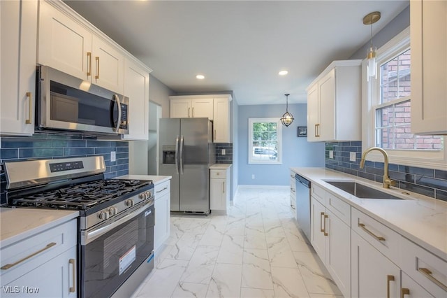 17607 Scottsdale Blvd, Shaker Heights, OH 44120 - kitchen with appliances with stainless steel finishes, a sink, light marble finish flooring, recessed lighting, and decorative light fixtures
