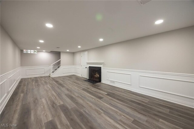 17607 Scottsdale Blvd, Shaker Heights, OH 44120 - finished basement featuring a decorative wall, recessed lighting, a wainscoted wall, dark wood-style flooring, and a fireplace with flush hearth