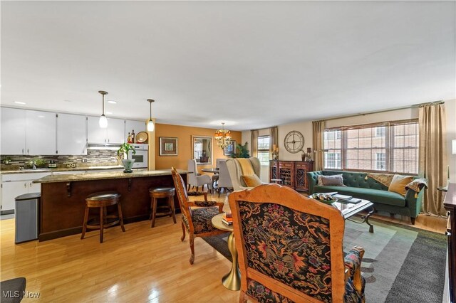 18975 Van Aken Blvd Unit 401, Shaker Heights, OH 44122 - living room featuring light wood-type flooring and a chandelier
