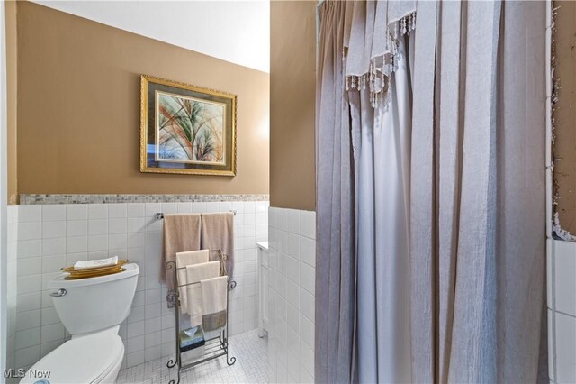 18975 Van Aken Blvd Unit 401, Shaker Heights, OH 44122 - full bath featuring toilet, tile walls, wainscoting, tile patterned flooring, and a shower with shower curtain