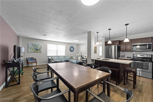 18975 Van Aken Blvd Unit 401, Shaker Heights, OH 44122 - dining area with wood finished floors, a textured ceiling, and baseboards