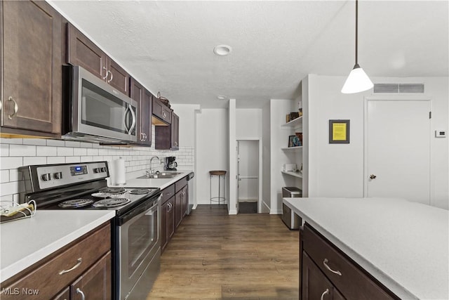 18975 Van Aken Blvd Unit 401, Shaker Heights, OH 44122 - kitchen featuring appliances with stainless steel finishes, a sink, light countertops, dark wood finished floors, and decorative backsplash