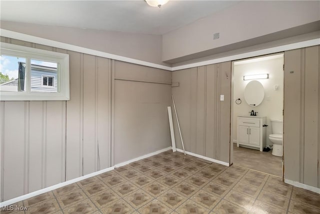 3338 E 130th St, Cleveland, OH 44120 - unfurnished bedroom with lofted ceiling, connected bathroom, a decorative wall, and a closet