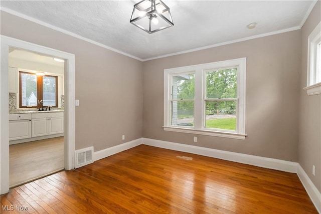 3338 E 130th St, Cleveland, OH 44120 - unfurnished room with light wood-style flooring, baseboards, ornamental molding, and a sink