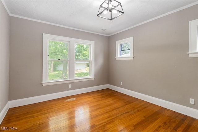 3338 E 130th St, Cleveland, OH 44120 - empty room with baseboards, wood-type flooring, crown molding, and a chandelier