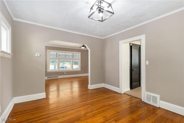 3338 E 130th St, Cleveland, OH 44120 - empty room with wood finished floors, ceiling fan, baseboards, and crown molding
