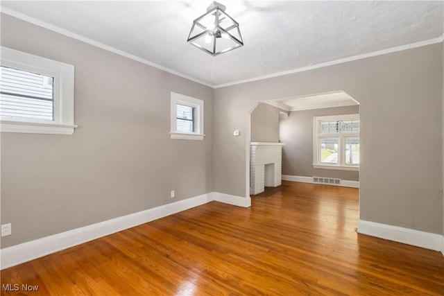 3338 E 130th St, Cleveland, OH 44120 - unfurnished room featuring arched walkways, wood finished floors, baseboards, and crown molding