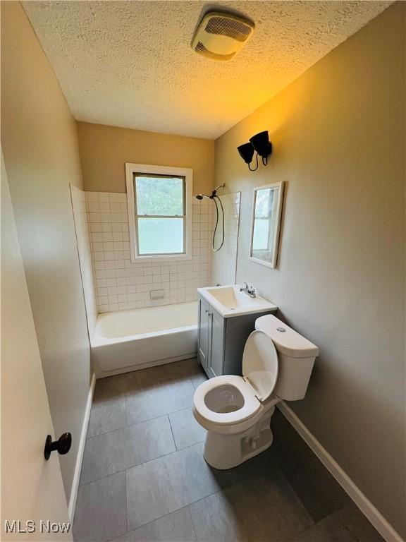 4780 E 173rd St, Cleveland, OH 44128 - full bathroom featuring toilet, a textured ceiling, baseboards, vanity, and washtub / shower combination