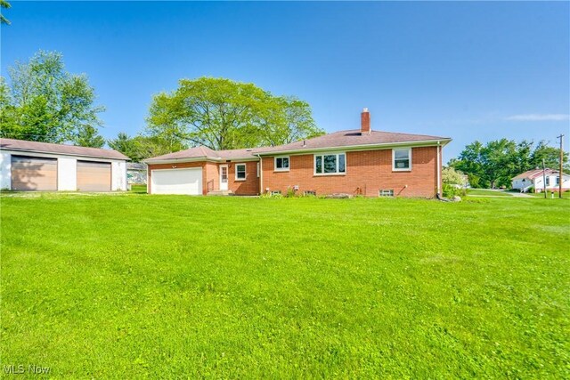 340 53rd St SW, Canton, OH 44706 - rear view of house with a chimney, a yard, brick siding, and a detached garage
