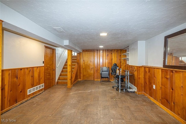 21202 Franklin Rd, Maple Heights, OH 44137 - workout area featuring wooden walls, a wainscoted wall, and a textured ceiling