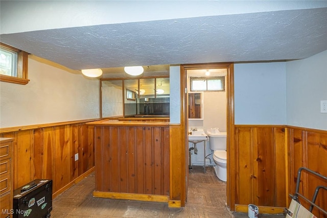 21202 Franklin Rd, Maple Heights, OH 44137 - indoor bar featuring a wainscoted wall, a textured ceiling, wood walls, and wood finished floors