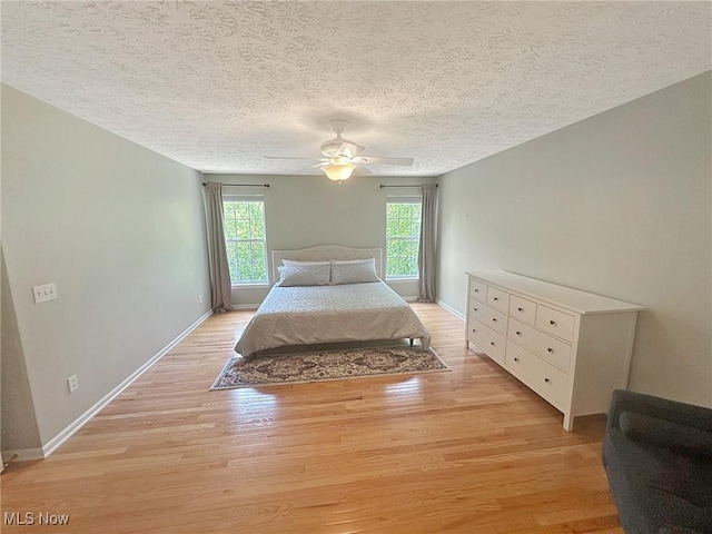 15532 Raya Oval, North Royalton, OH 44133 - bedroom with light wood-style flooring, baseboards, a textured ceiling, and a ceiling fan