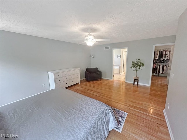 15532 Raya Oval, North Royalton, OH 44133 - bedroom with a textured ceiling, light wood finished floors, a spacious closet, baseboards, and a ceiling fan