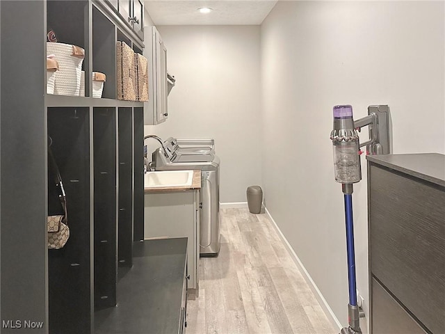 15532 Raya Oval, North Royalton, OH 44133 - washroom with cabinet space, baseboards, washer and dryer, and light wood-style flooring