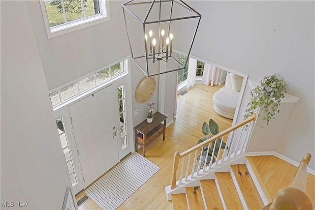 15532 Raya Oval, North Royalton, OH 44133 - foyer with stairs, a towering ceiling, wood finished floors, a chandelier, and baseboards
