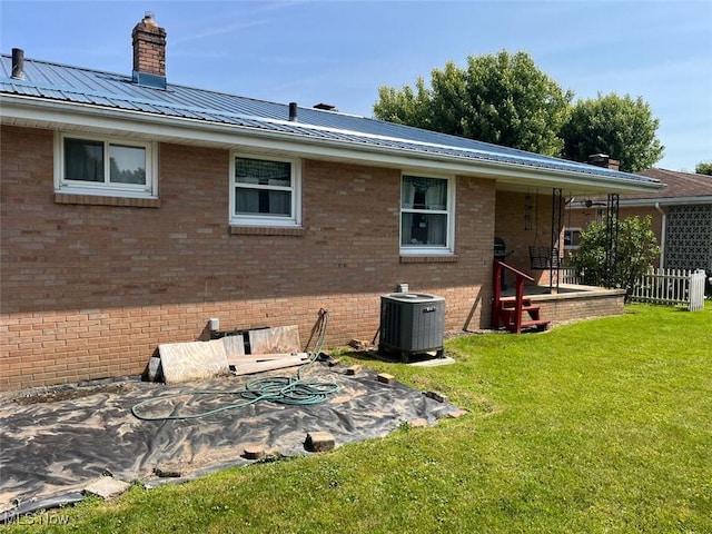 812 Ike St, Minerva, OH 44657 - back of house featuring brick siding, central air condition unit, a chimney, and metal roof