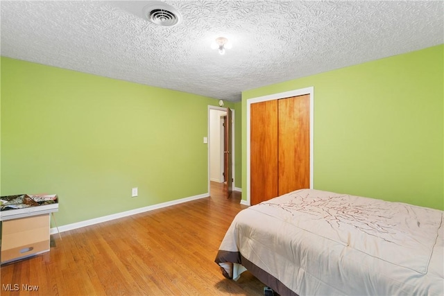 3467 Marian Rd, Ravenna, OH 44266 - bedroom featuring wood finished floors, baseboards, a closet, and a textured ceiling