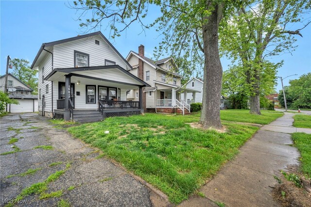 15417 Parkgrove Ave, Cleveland, OH 44110 - view of front of home featuring covered porch, an outdoor structure, and a front lawn
