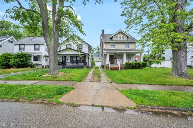 15417 Parkgrove Ave, Cleveland, OH 44110 - american foursquare style home with covered porch, a front lawn, and a chimney