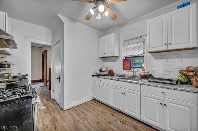 15417 Parkgrove Ave, Cleveland, OH 44110 - kitchen featuring stainless steel gas stove, light wood-style floors, a ceiling fan, backsplash, and white cabinetry