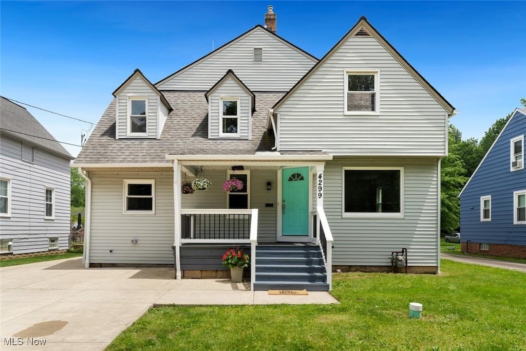 4299 Clague Rd, North Olmsted, OH 44070 - view of front of home with covered porch, a front lawn, roof with shingles, and a chimney