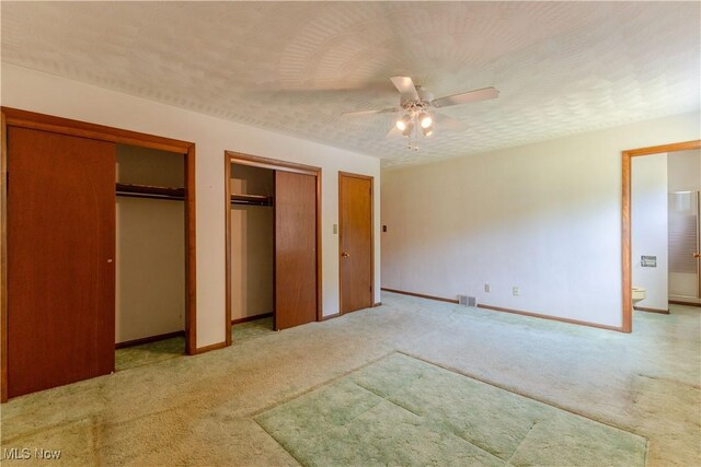 41510 Alderlick Rd, Wellsville, OH 43968 - unfurnished bedroom with light colored carpet, two closets, baseboards, ensuite bath, and a ceiling fan