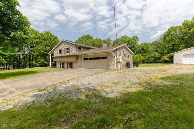 41510 Alderlick Rd, Wellsville, OH 43968 - view of front facade featuring a chimney, brick siding, a front yard, and a garage