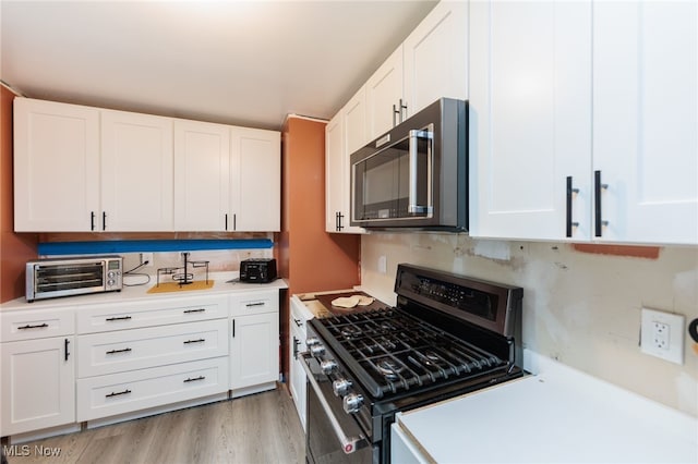 10229 State Rd, North Royalton, OH 44133 - kitchen with stainless steel gas stove, light countertops, white cabinetry, and decorative backsplash