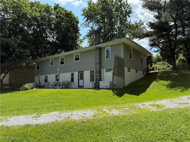 5301 S Ridge Rd W, Ashtabula, OH 44004 - back of property with a chimney, a lawn, an attached garage, and driveway