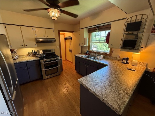 5301 S Ridge Rd W, Ashtabula, OH 44004 - kitchen with appliances with stainless steel finishes, a sink, under cabinet range hood, wood finished floors, and white cabinets