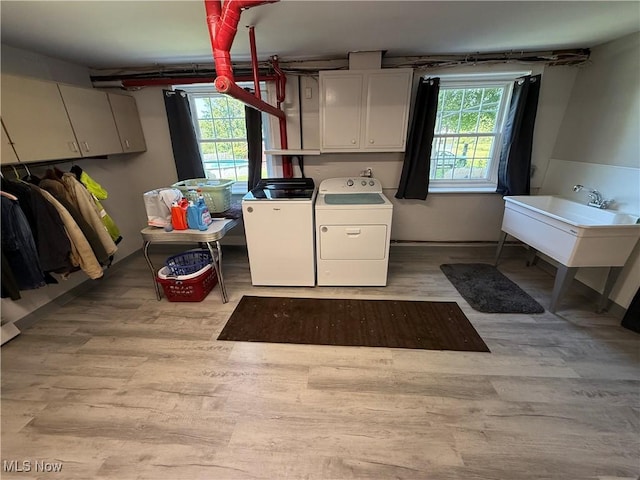5301 S Ridge Rd W, Ashtabula, OH 44004 - laundry room featuring independent washer and dryer, cabinet space, and light wood finished floors