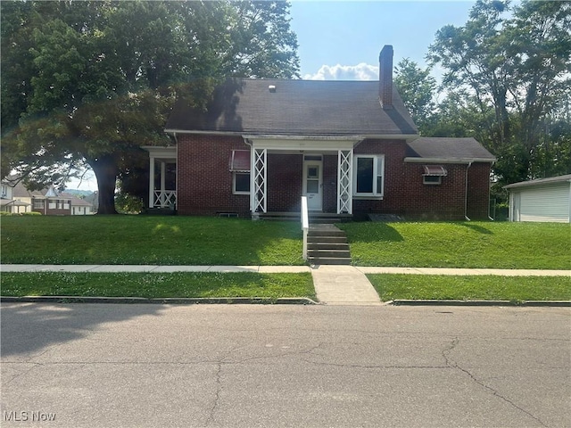 307 N 8th St, Coshocton, OH 43812 - view of front of home featuring brick siding, a front yard, and a chimney