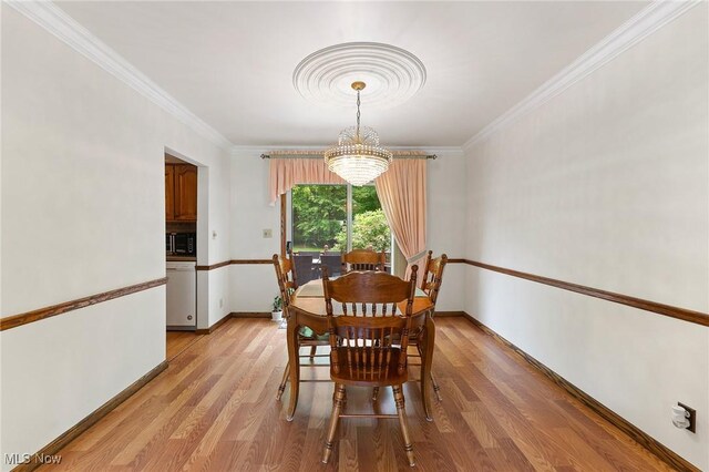 2322 Westview Rd, Cortland, OH 44410 - dining area with a chandelier, crown molding, light wood-style flooring, and baseboards
