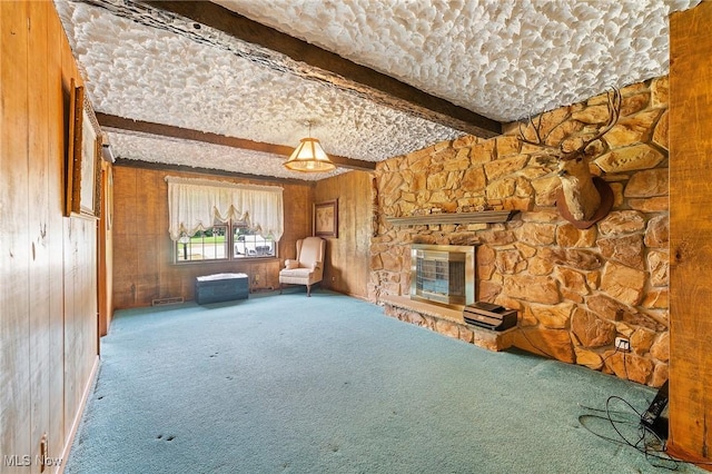 2322 Westview Rd, Cortland, OH 44410 - unfurnished living room with carpet floors, beamed ceiling, a stone fireplace, and wood walls