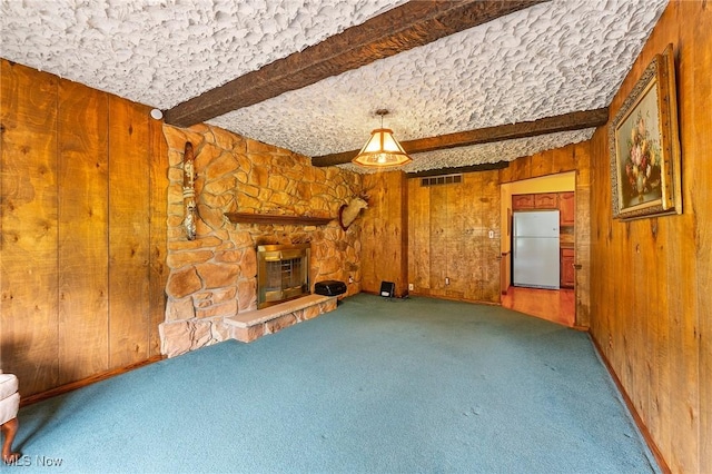 2322 Westview Rd, Cortland, OH 44410 - unfurnished living room featuring beam ceiling, wood walls, carpet flooring, and a stone fireplace