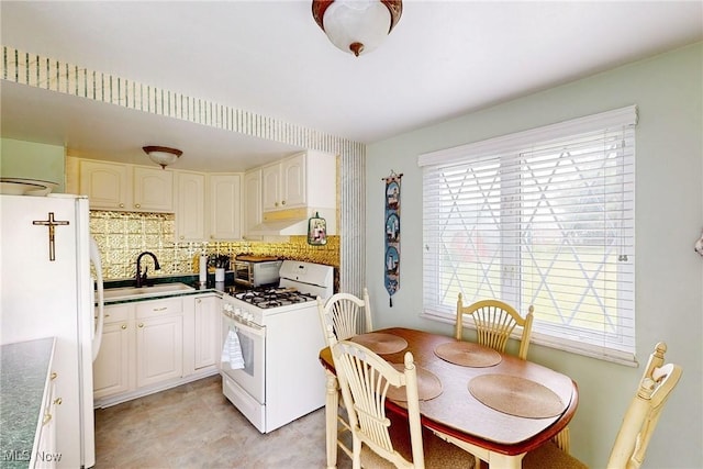 132 Karen Pl, Wintersville, OH 43953 - kitchen with white appliances, a sink, decorative backsplash, white cabinets, and under cabinet range hood