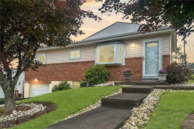 132 Karen Pl, Wintersville, OH 43953 - view of front facade with brick siding, a front lawn, and a garage