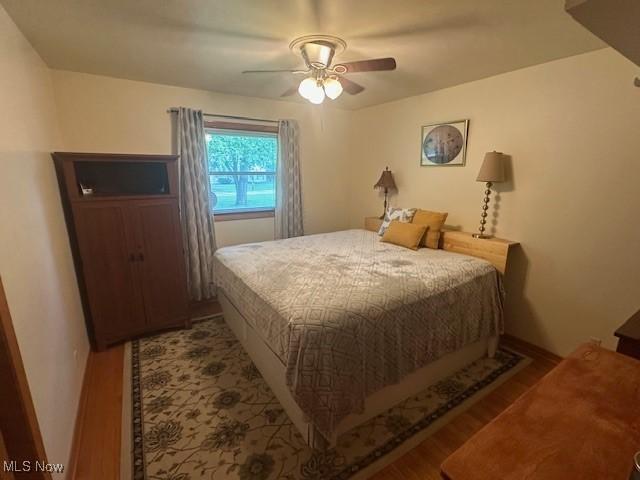 3232 Circle Dr, Cortland, OH 44410 - bedroom with wood finished floors, a ceiling fan, and baseboards