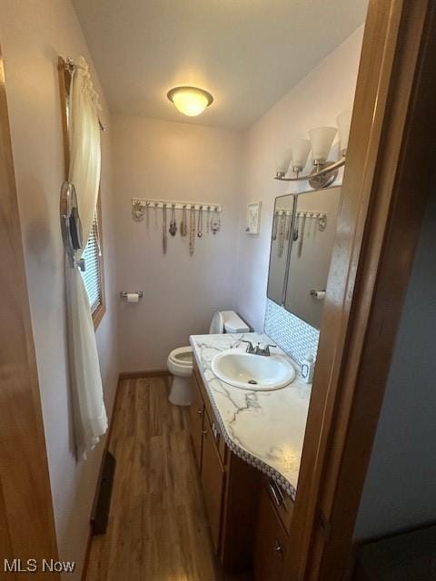 3232 Circle Dr, Cortland, OH 44410 - bathroom featuring vanity, wood finished floors, toilet, and baseboards