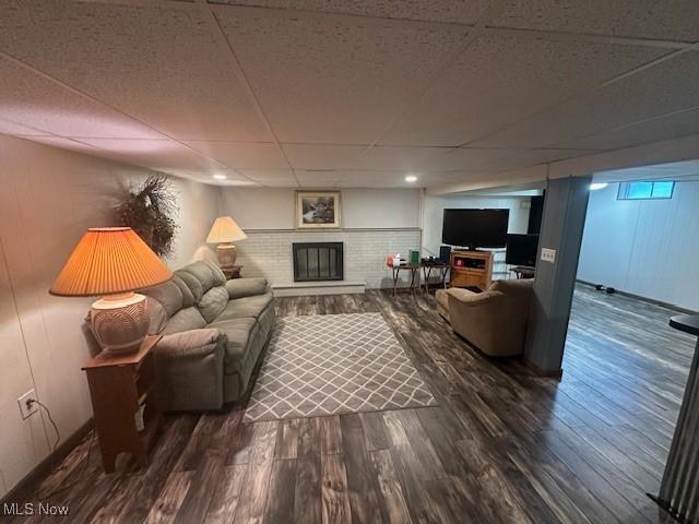 3232 Circle Dr, Cortland, OH 44410 - living area featuring a drop ceiling, wood finished floors, and a brick fireplace