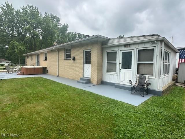 3232 Circle Dr, Cortland, OH 44410 - back of property featuring a hot tub, entry steps, a patio, and a lawn