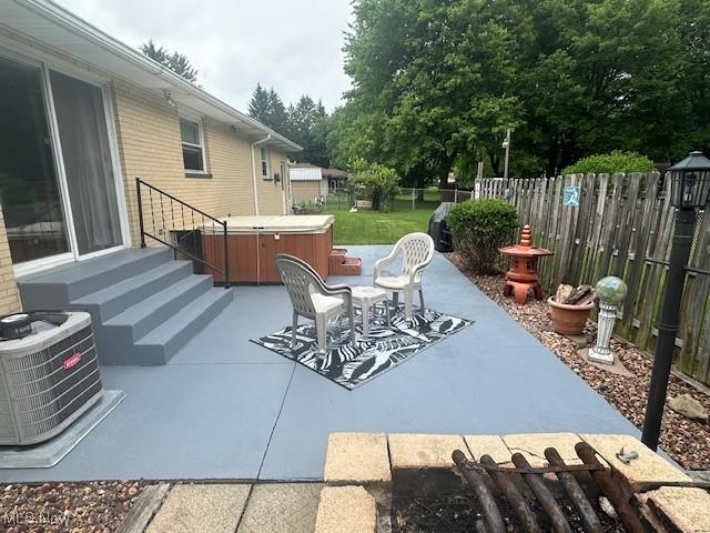 3232 Circle Dr, Cortland, OH 44410 - fenced backyard featuring a hot tub, central AC unit, and a patio area