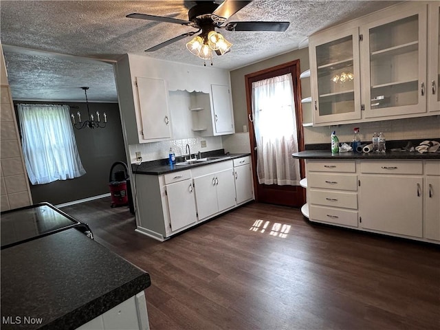 1029 Fowler Dr, Caldwell, OH 43724 - kitchen featuring dark countertops, dark wood-style floors, a sink, a textured ceiling, and a chandelier