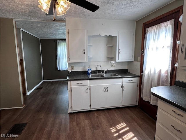 1029 Fowler Dr, Caldwell, OH 43724 - kitchen featuring a sink, a textured ceiling, dark countertops, white cabinets, and dark wood-style flooring