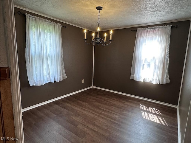 1029 Fowler Dr, Caldwell, OH 43724 - spare room with a textured ceiling, a chandelier, wood finished floors, crown molding, and baseboards